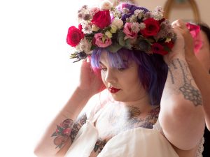 9 month pregnant Bride is doing her brightly coloured hair and adjusting her oversized flower crown ahead of her wedding at West Bridgford