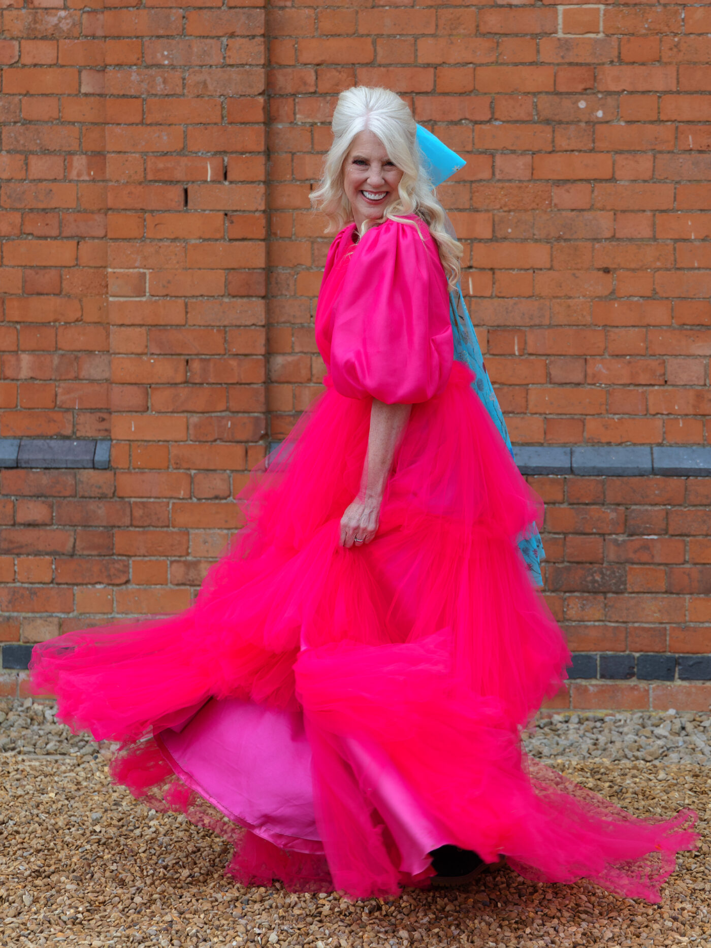 Beauty in Diversity shoot. A female wearing a beautiful bright pink dress twirls happily