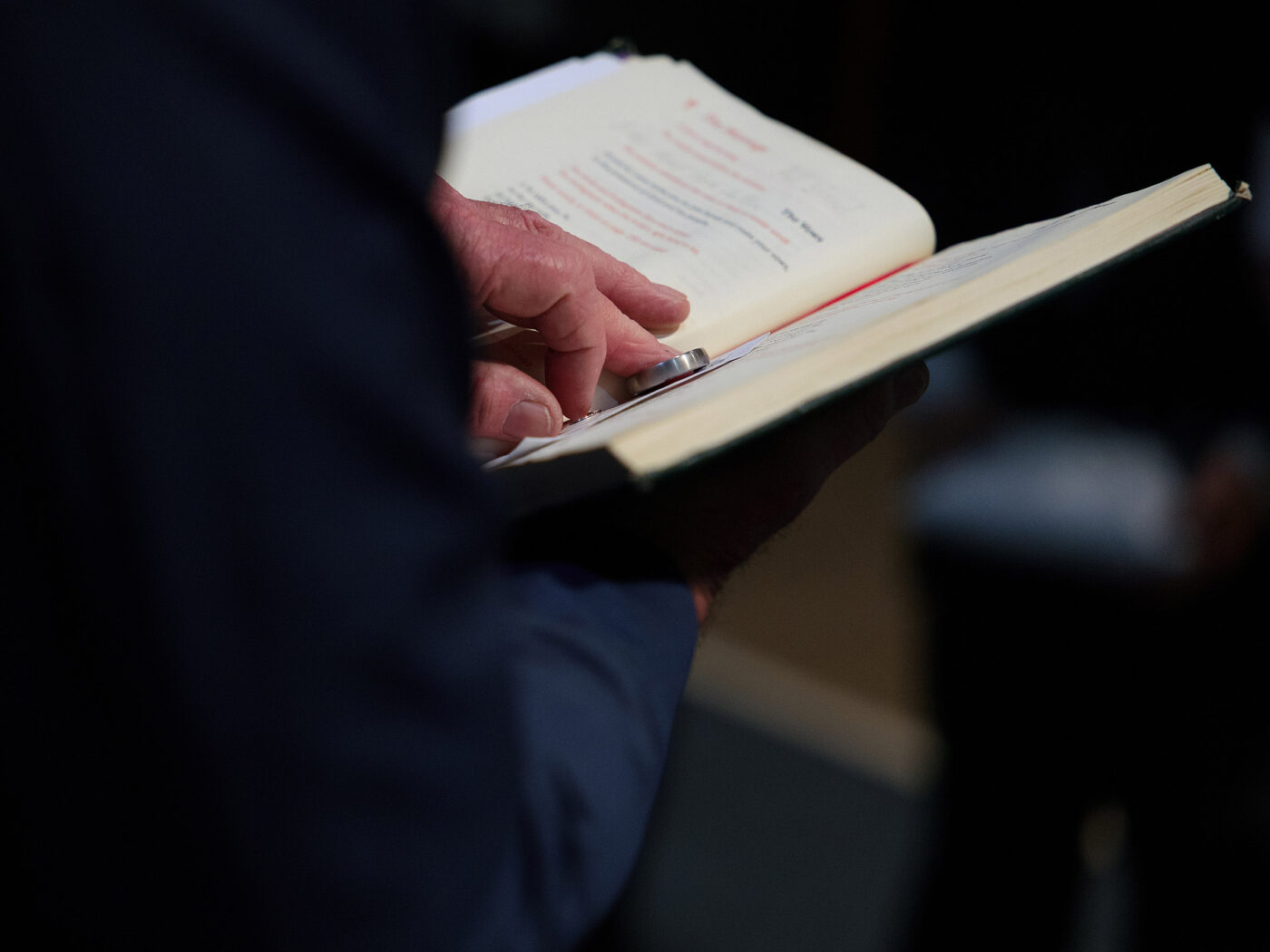 Wedding rings are resting on the open pages of a Bible. The Vicar is blessing the rings and the marriage