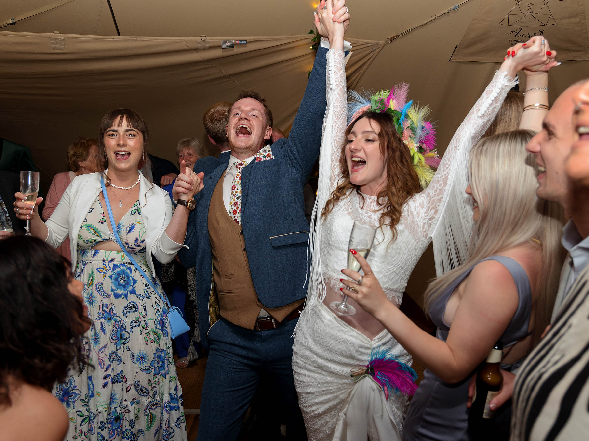Bride and groom holding hands in the air, on the dance floor singing, The photo accompanies a wonderful review of pink photographics work