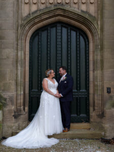 Bride and Groom are stood holding hands in a large doorway at their wedding at The Sessions House Spalding